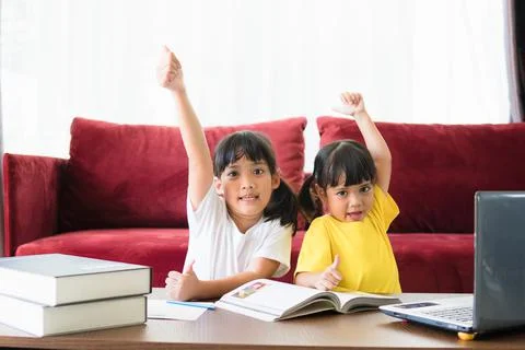Two asian child girl students study online with teacher by video call togethe 写真素材