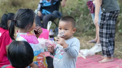 Two asian children Sharing soft drinks in Khon Kaen, Thailand on 20 Decembe.. Stock Footage 259690868