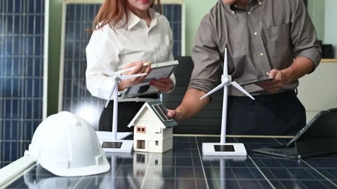 Two Asian engineers collaborate on a solar and wind energy project, discuss.. Stock Footage 313266537