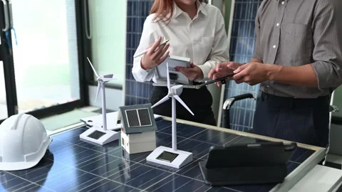 Two Asian engineers collaborate on a solar and wind energy project, discuss.. Stock Footage 313266542
