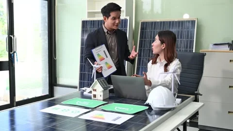 Two Asian engineers collaborate on a solar and wind energy project, discuss.. Stock Footage 313266544