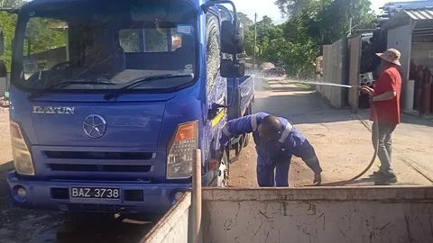 Two Asian Male Workers Wash Truck With Pipe Water In The Morning Stock Footage 309306953