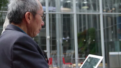 Two Asian Men Looking at an Ipad Stock Footage 36136061