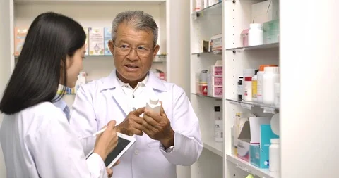 Two asian pharmacist checking medicines in pharmacy. Stock Footage 124231879
