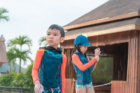 Two Asian siblings in playing together in Water Aqua park pool. Stock Photos