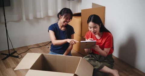  Two Asian siblings sit on the floor, looking at a picture frame Video stock 294662535