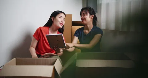  Two Asian siblings sit on the floor, looking at a picture frame Stockbeeldmateriaal 294663914