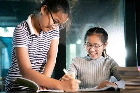 Two asian student reading a school book with happiness emotion Stock Photos