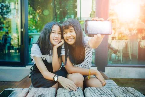 Two asian teenager show white screen of  smart phone screen  and toothy smili Stock Photos