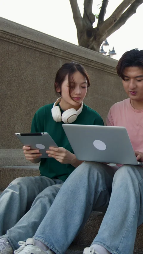 Two Asian University Students Studying Together on Campus Stairs with Laptop Stock Footage 342686479