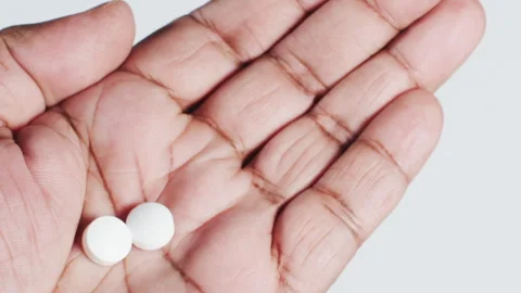 Two Aspirin tablets in the palm of a hand Vídeo Stock 248754658