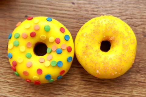 Two assorted donuts on a wood background Stock Photos