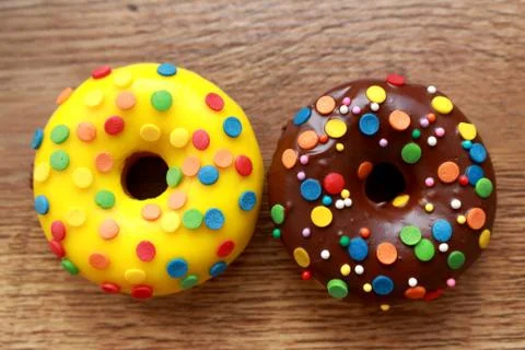 Two assorted donuts on a wood background Stock Photos