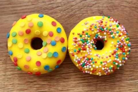 Two assorted donuts on a wood background Stock Photos