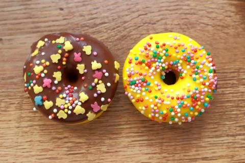 Two assorted donuts on a wood background Stock Photos