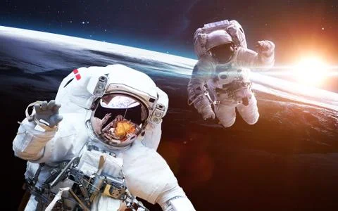Two astronauts orbiting Earth planet Stock Photos