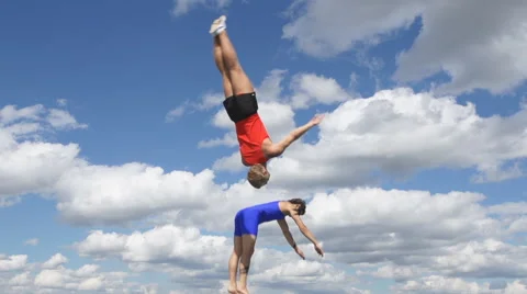 Two Athlete jumps on trampoline on background of clouds 库存影片 57170868