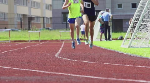 Two athlete run on a stadium track - slow motion, feet level Stock Footage 64841203