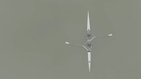 Two athletes rowing a sculling boat on calm water, teamwork and endurance in Stock Footage 319529880