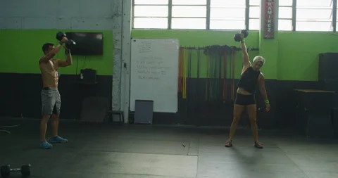 Two athletes training with dumbbells Stock Footage 96950763