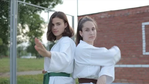 Two athletes women demonstrate a basic karate stance standing with their backs 스톡 동영상 140546114