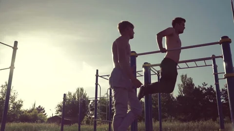 Two athletic mens training on parallel crossbars Stock Footage 90932712