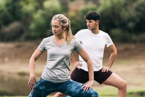 Two athletic people doing strides in a park Stock Photos