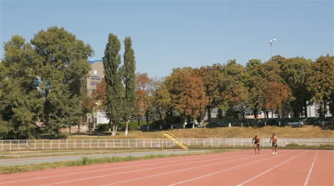 Two athlets sprinting at the stadium Видео 68318628