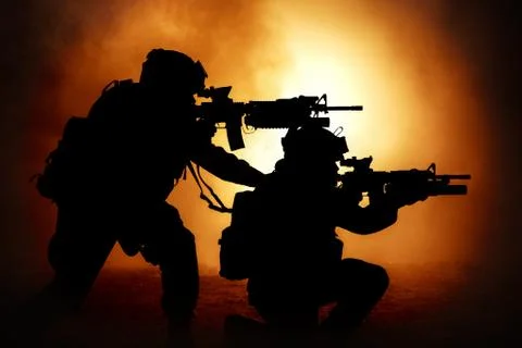 Two attacking soldiers surrounded flame and smoke Foto stock