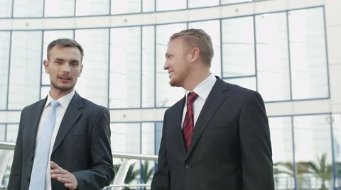 Two attractive businessmen going along office building Video stock 52821653