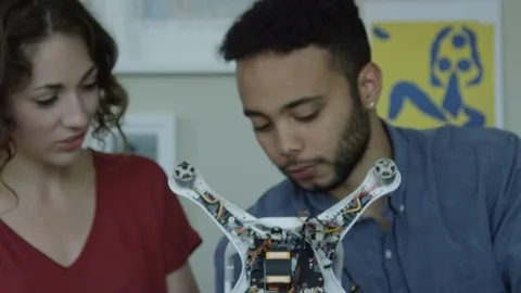 Two Attractive Coders With A Robot They Have Built Stock Footage 82403512