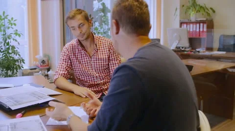 Two attractive men discuss the plan of construction of the house Stock Footage 58017008