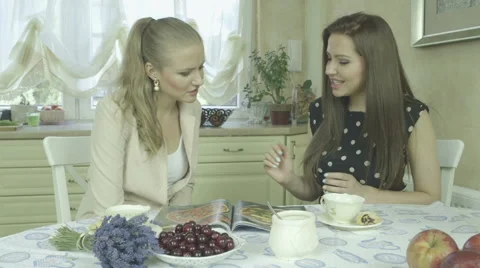 Two attractive smiling young friends having relaxing time at dining table Stock Footage 40109301