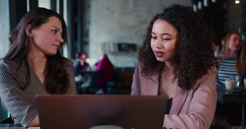 Two attractive young confident multiethnic business women work together using Stock Footage 152486397