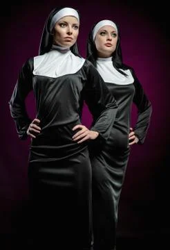 Two attractive young nuns posing indoors Stock Photos