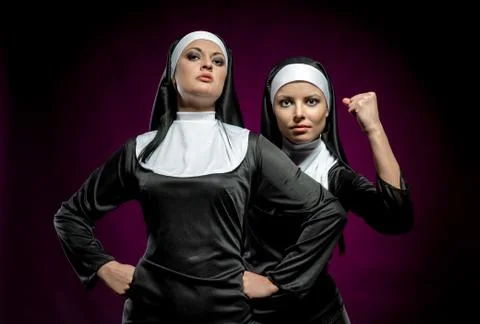 Two attractive young nuns posing indoors Stock Photos