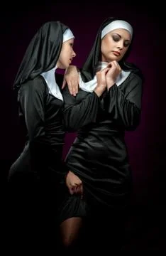 Two attractive young nuns posing indoors Stock Photos