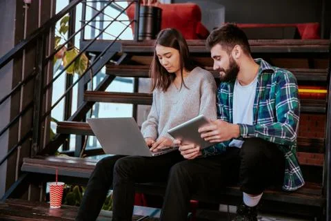 Two attractive young office workers analyzing the plan of work using the Stock Photos