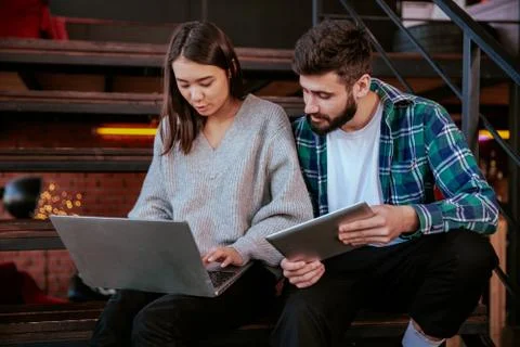 Two attractive young office workers analyzing the plan of work using the Stock Photos