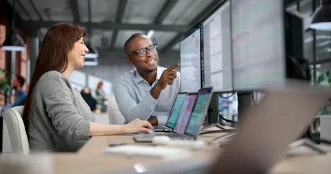 Two Auditors And Analysts Carefully Review Financial Data On Computer Screens Foto stock