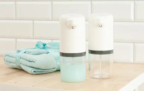 Two automatic soap dispenser. One with soap, the other is empty .. On the bac Stock Photos