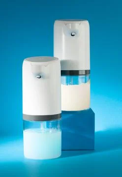 Two automatic soap dispensers. One with a solution of soap, the other empty.  Stock Photos
