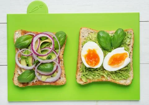 Two avocado toasts on green background Stock Photos