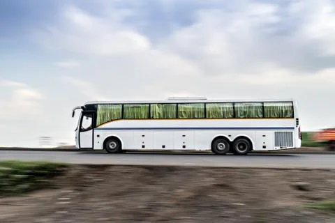 Two axle, rear engine, air-conditioned luxury bus , speeding on a highway. Stock Photos