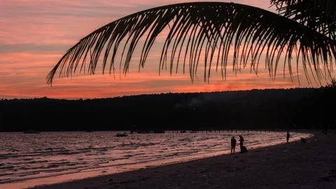 Two Backpacker walking on the beach at sunset Stock Photos