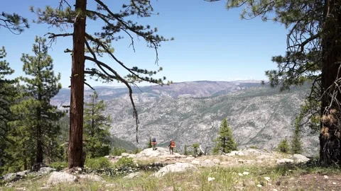 Two Backpackers Ascend a Mountain Peak to Enjoy the Scenic View Stock Footage 242024652