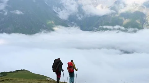 Two Backpackers descending Mount Kazbegi Stock Footage 248614179