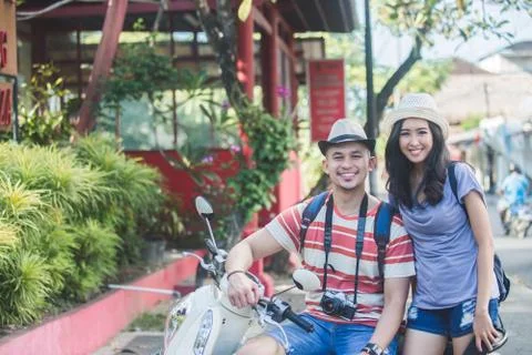 Two backpackers with summer hat smiling to camera while sitting Stock Photos