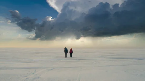 The two backpackers trekking through the icy snow field Stock Footage 189350994