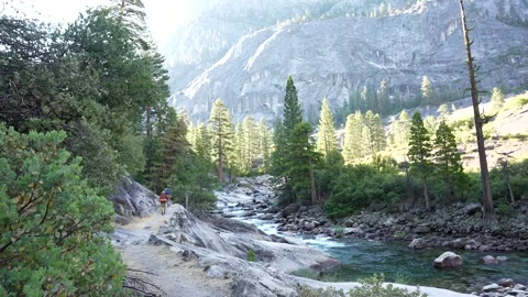 Two backpackers walking on a River Trail with Scenic View in a Mountains Stock Footage 242025187